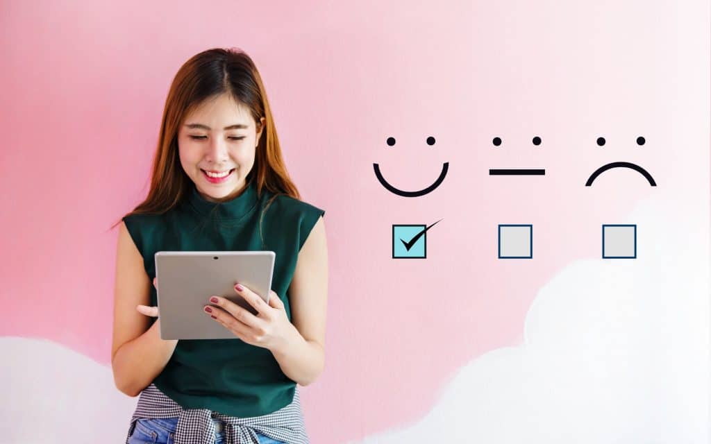 Photo of a woman depicting a positive review, with happy, okay, and sad vector emojis photos.